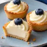 Cheesecake cookie cups with golden sugar cookie shells, vanilla filling and a blueberry garnish
